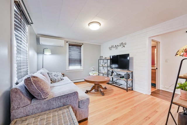 living area with a baseboard heating unit, an AC wall unit, and wood finished floors