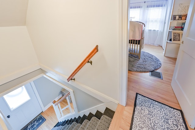 stairs featuring wood finished floors and visible vents