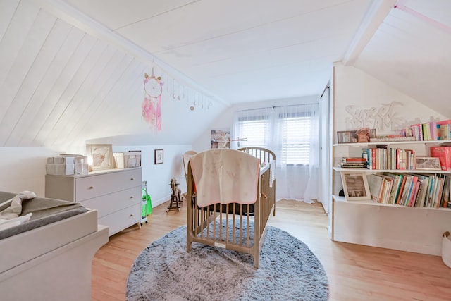 bedroom with vaulted ceiling and wood finished floors