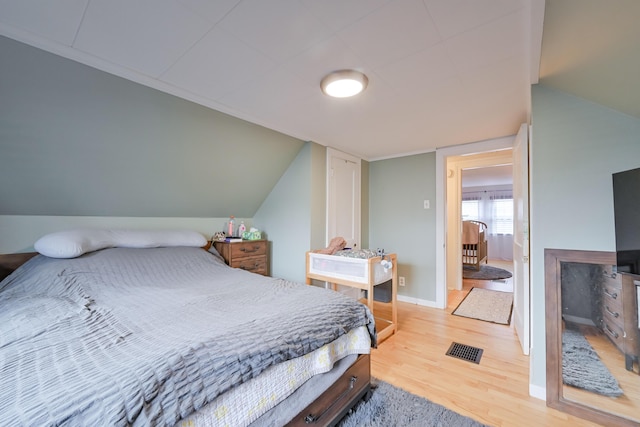 bedroom featuring visible vents, baseboards, and wood finished floors