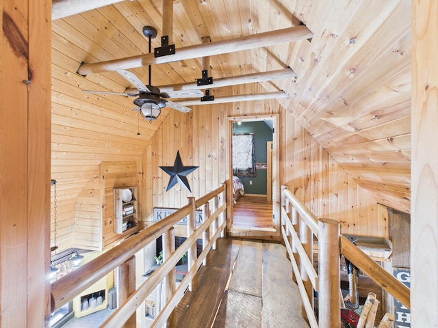 corridor featuring an upstairs landing, wooden walls, wood ceiling, and lofted ceiling with beams