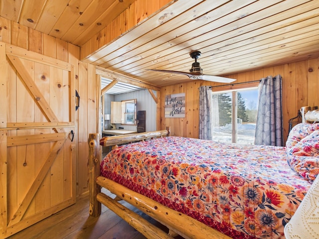 bedroom featuring wooden walls, wood ceiling, hardwood / wood-style floors, and access to outside