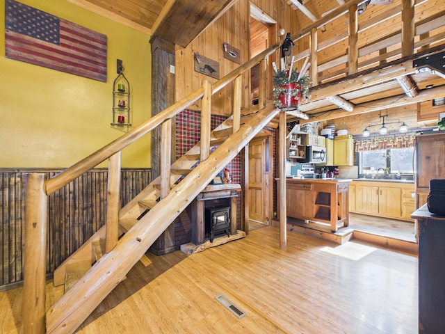 stairs featuring wooden ceiling, beamed ceiling, wood finished floors, and visible vents