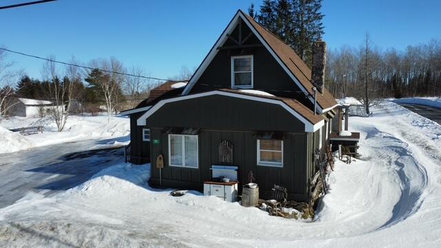 view of front facade with board and batten siding and a chimney