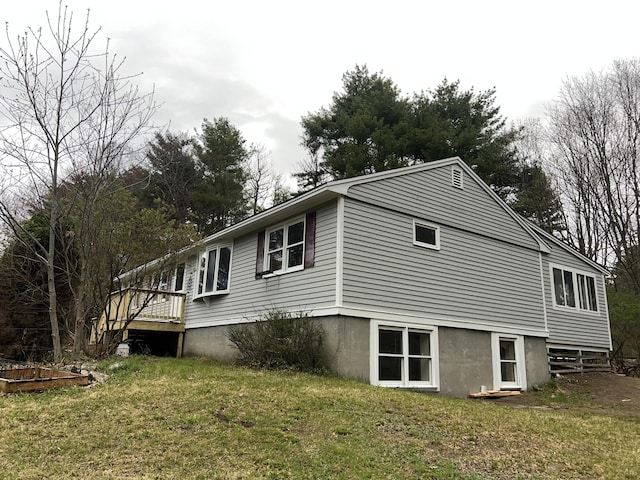 view of property exterior with a yard and a deck
