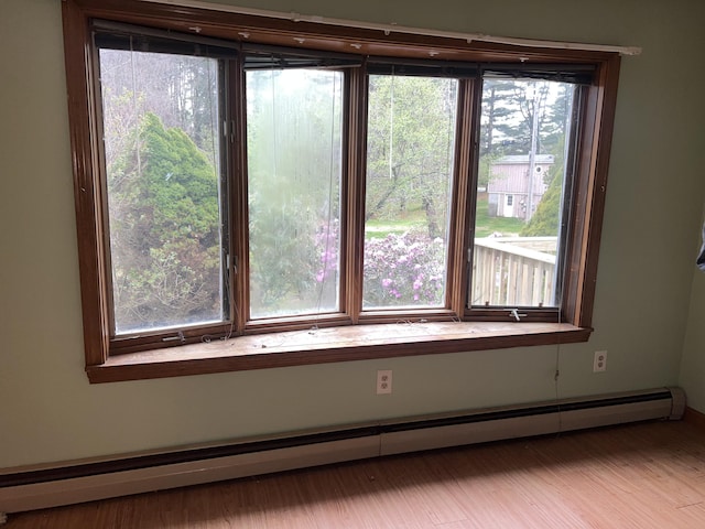 empty room featuring a wealth of natural light and baseboard heating