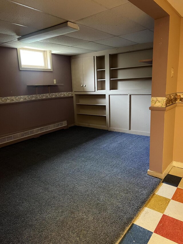 below grade area with baseboard heating and tile patterned floors