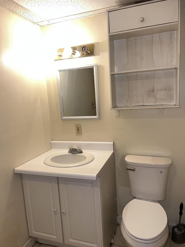 half bath featuring vanity, toilet, and baseboards