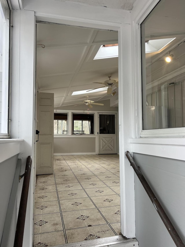 hallway featuring a skylight and light tile patterned floors