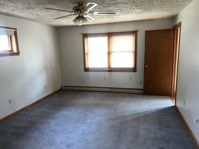 carpeted spare room featuring a baseboard radiator, a textured ceiling, a wealth of natural light, and ceiling fan