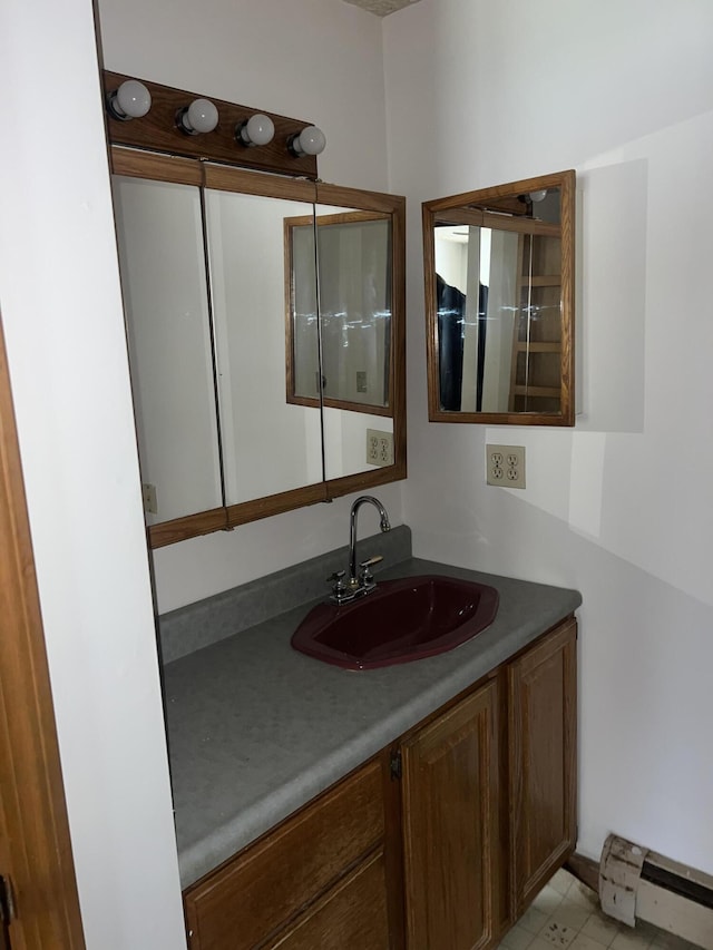 bathroom featuring baseboard heating and vanity