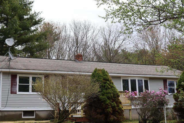 view of side of home with a wooden deck and a chimney