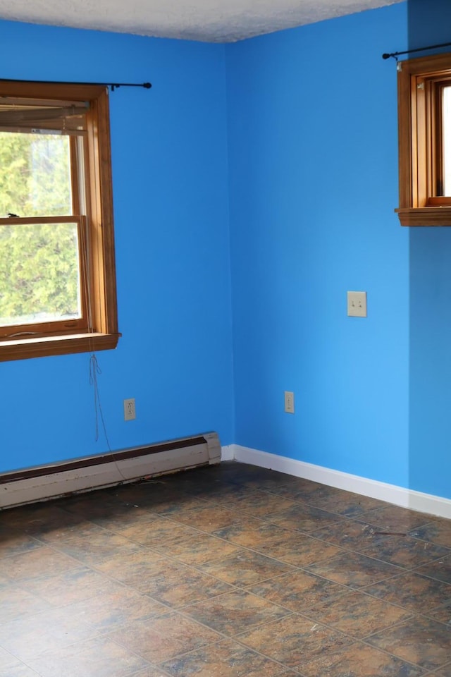 empty room featuring baseboards and a baseboard radiator