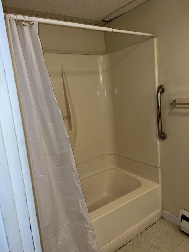 full bath with baseboards, shower / bath combo, and a baseboard heating unit
