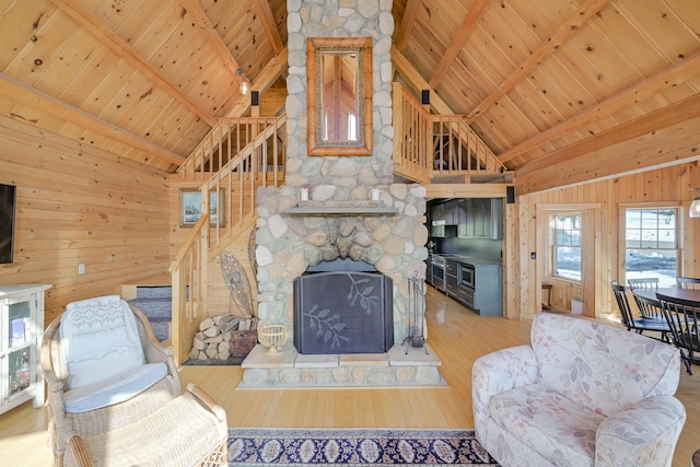 84 Ira Mountain Rd, Kingfield, ME 04947 - living room with wooden walls, hardwood / wood-style flooring, stairs, wood ceiling with exposed beams, and high vaulted ceiling