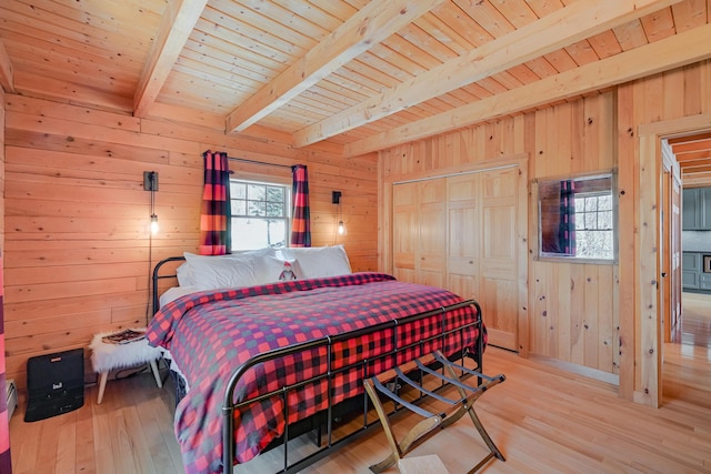 84 Ira Mountain Rd, Kingfield, ME 04947 - bedroom featuring wood walls, light wood-style floors, wooden ceiling with exposed beams, and a closet