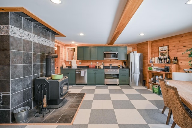 84 Ira Mountain Rd, Kingfield, ME 04947 - kitchen with green cabinets, appliances with stainless steel finishes, a wood stove, dark countertops, and light flooring