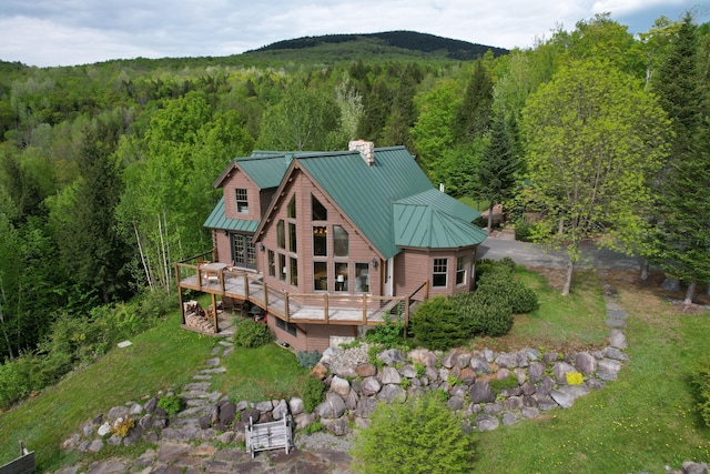 84 Ira Mountain Rd, Kingfield, ME 04947 - back of house with a forest view, a wooden deck, a chimney, metal roof, and a standing seam roof