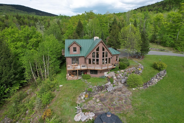 84 Ira Mountain Rd, Kingfield, ME 04947 - rear view of house featuring a wooded view, a chimney, a deck, and a lawn