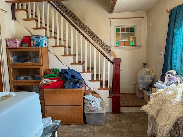 staircase featuring stone finish floor