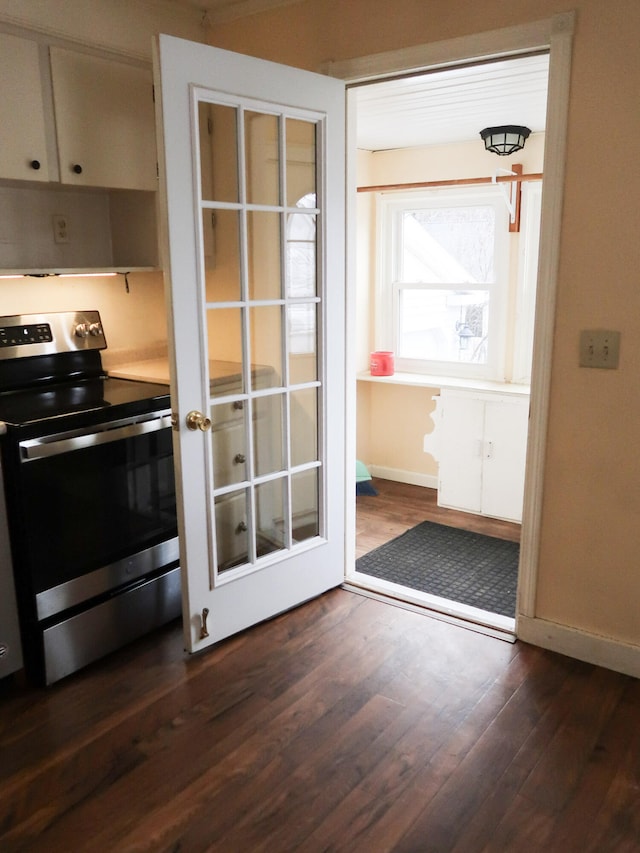 kitchen featuring baseboards, dark wood-type flooring, and electric stove