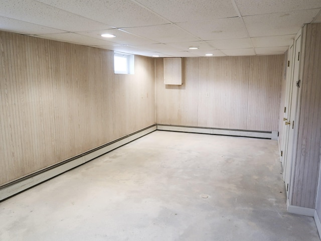 below grade area featuring a paneled ceiling and wooden walls