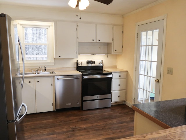 kitchen with ornamental molding, white cabinetry, stainless steel appliances, ceiling fan, and dark wood-style flooring