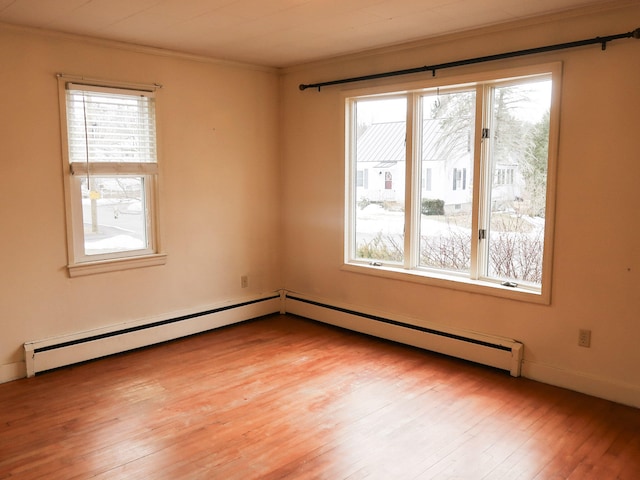 unfurnished room with light wood-type flooring, a healthy amount of sunlight, crown molding, and a baseboard radiator