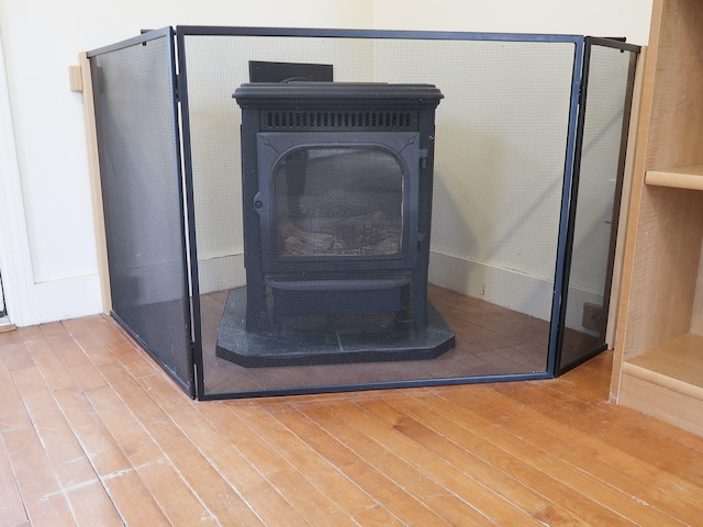 details with a wood stove and wood finished floors