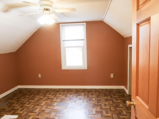 additional living space with a ceiling fan, baseboards, and vaulted ceiling