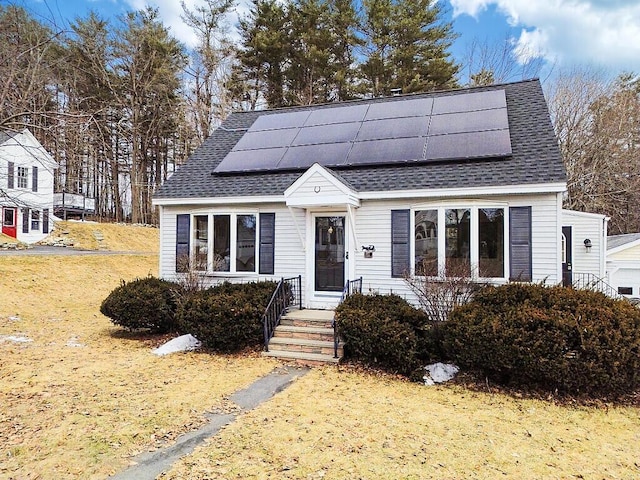 view of front of home featuring solar panels and a shingled roof