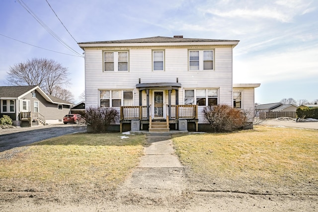 view of front facade featuring aphalt driveway and a front lawn