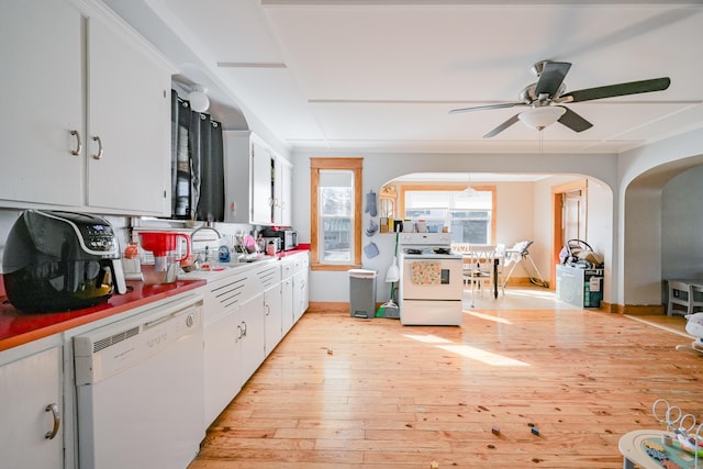 kitchen with light wood-style flooring, white appliances, arched walkways, and white cabinets