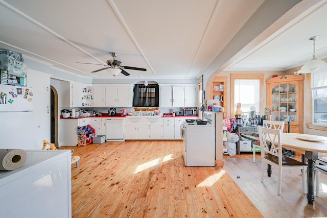 kitchen with arched walkways, white cabinets, white appliances, and light wood-type flooring