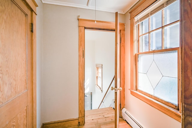 hall featuring an upstairs landing, wood finished floors, attic access, and a baseboard radiator