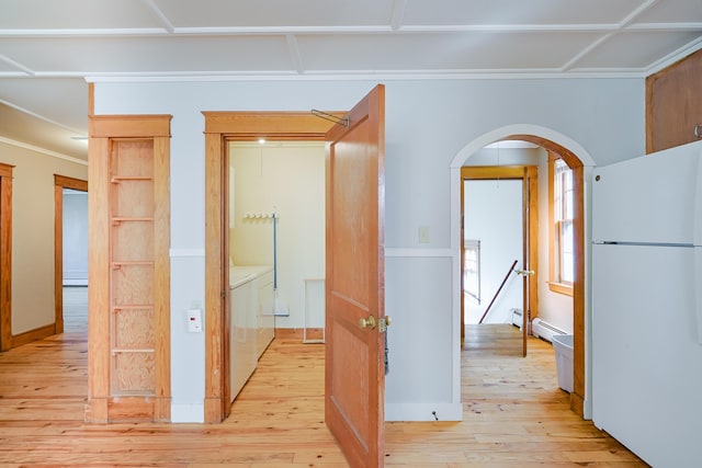 corridor featuring light wood-style floors, arched walkways, separate washer and dryer, and baseboard heating