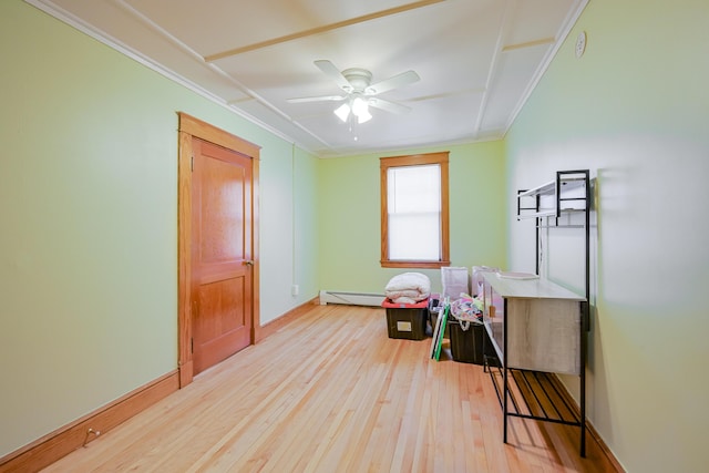 playroom featuring a ceiling fan, baseboards, light wood-style floors, a baseboard heating unit, and crown molding