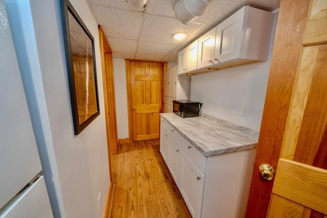 19 Glenview Ln, Belfast, ME 04915 - hallway featuring light wood-style flooring, a paneled ceiling, and a heating unit