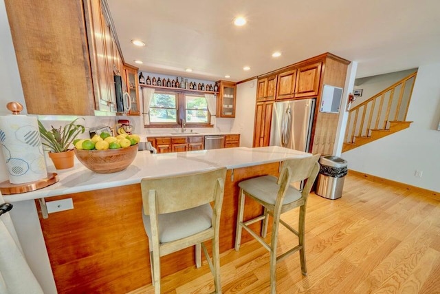 19 Glenview Ln, Belfast, ME 04915 - kitchen with stainless steel appliances, brown cabinets, a peninsula, light countertops, and light wood finished floors