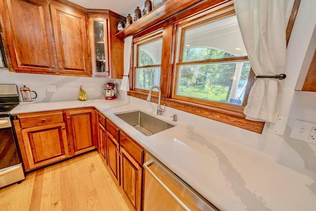 19 Glenview Ln, Belfast, ME 04915 - kitchen featuring appliances with stainless steel finishes, light countertops, brown cabinetry, light wood-style flooring, and glass insert cabinets