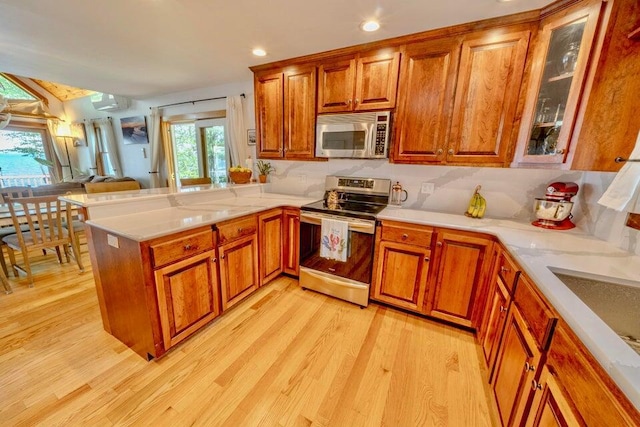 19 Glenview Ln, Belfast, ME 04915 - kitchen with appliances with stainless steel finishes, light wood-style flooring, brown cabinets, a peninsula, and recessed lighting