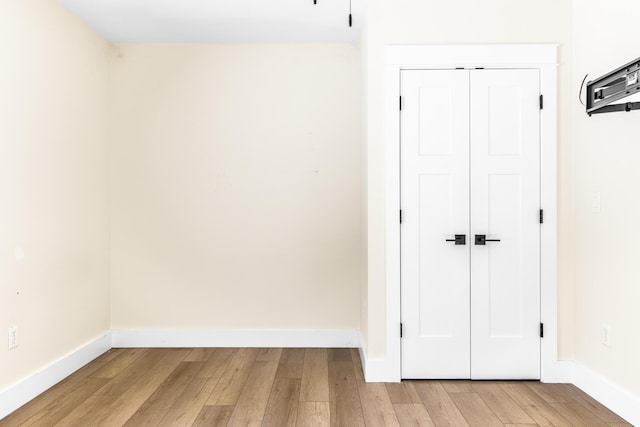 empty room featuring light wood-type flooring and baseboards