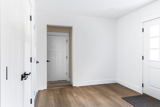 empty room with baseboards and light wood-type flooring