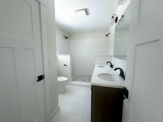 bathroom featuring tile patterned floors, a shower stall, toilet, and a sink