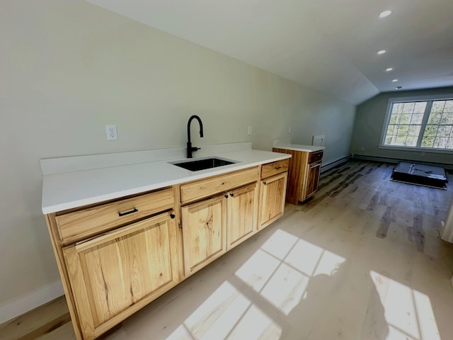 kitchen featuring light wood-type flooring, a sink, recessed lighting, baseboards, and lofted ceiling