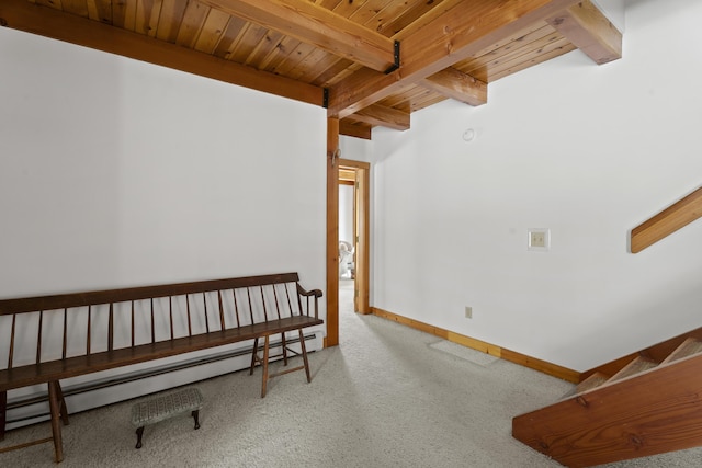 interior space featuring beamed ceiling, wood ceiling, a baseboard heating unit, and carpet
