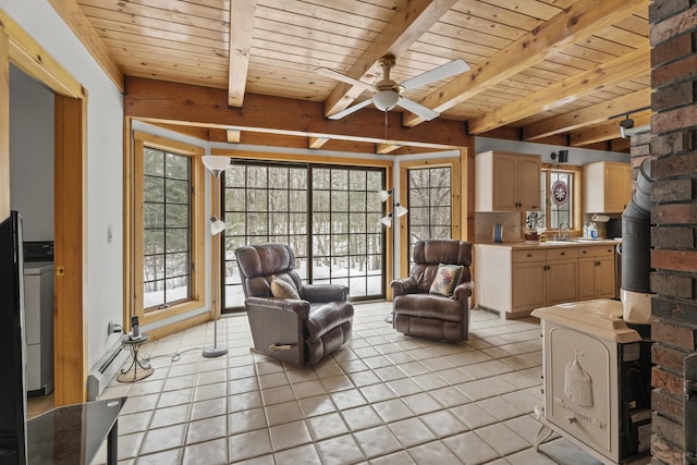 sitting room with ceiling fan, beam ceiling, wooden ceiling, and light tile patterned flooring