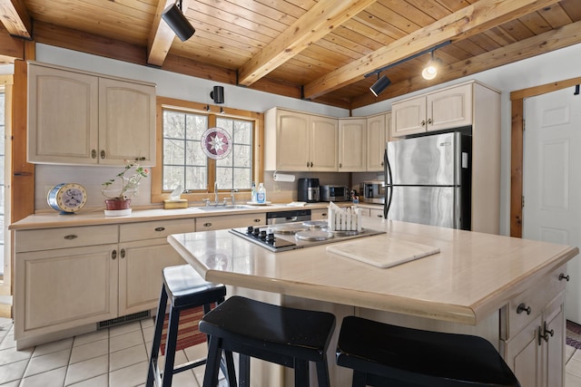 kitchen featuring light tile patterned floors, appliances with stainless steel finishes, wood ceiling, and a sink