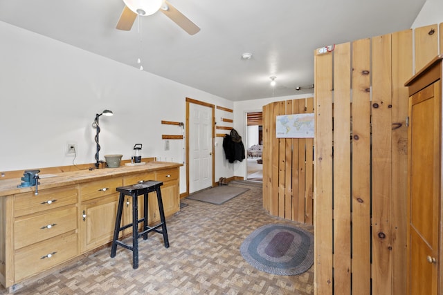 interior space with light floors and a ceiling fan