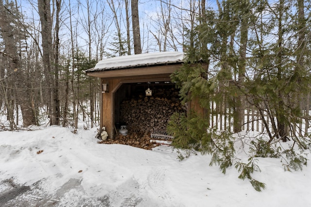 snow covered structure with an outbuilding